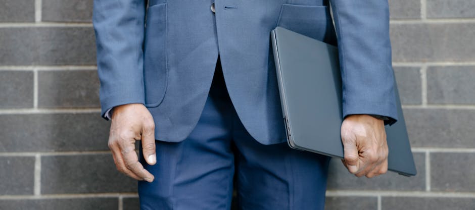 ノートとパソコンを前に考える若手社会人の写真